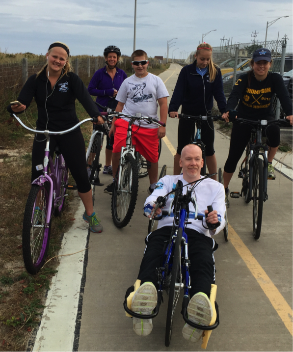 5 on bicycles behind one on a spinal cord injury retrofitted bike